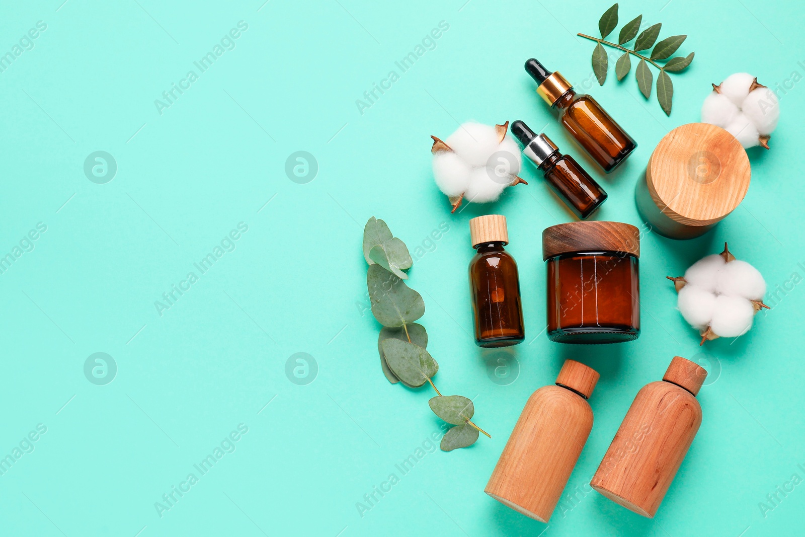 Photo of Different cosmetic products, leaves and cotton flowers on turquoise background, flat lay. Space for text