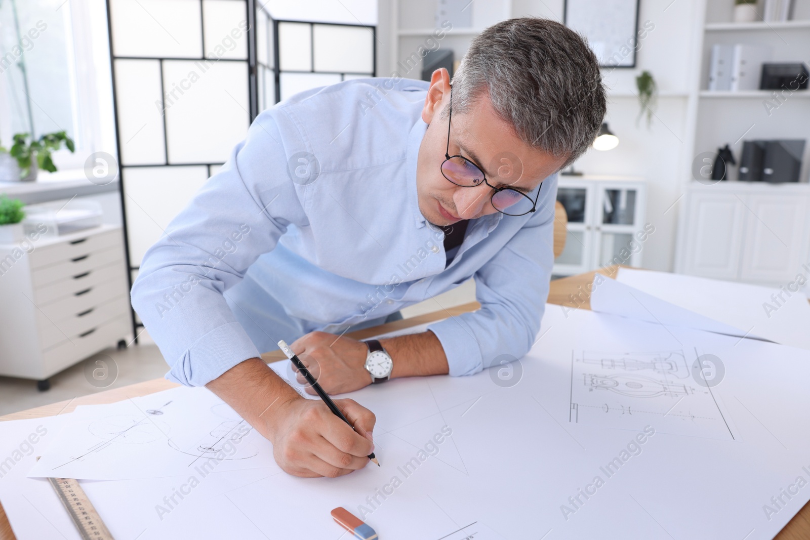 Photo of Architect making engineering drawing at table in office