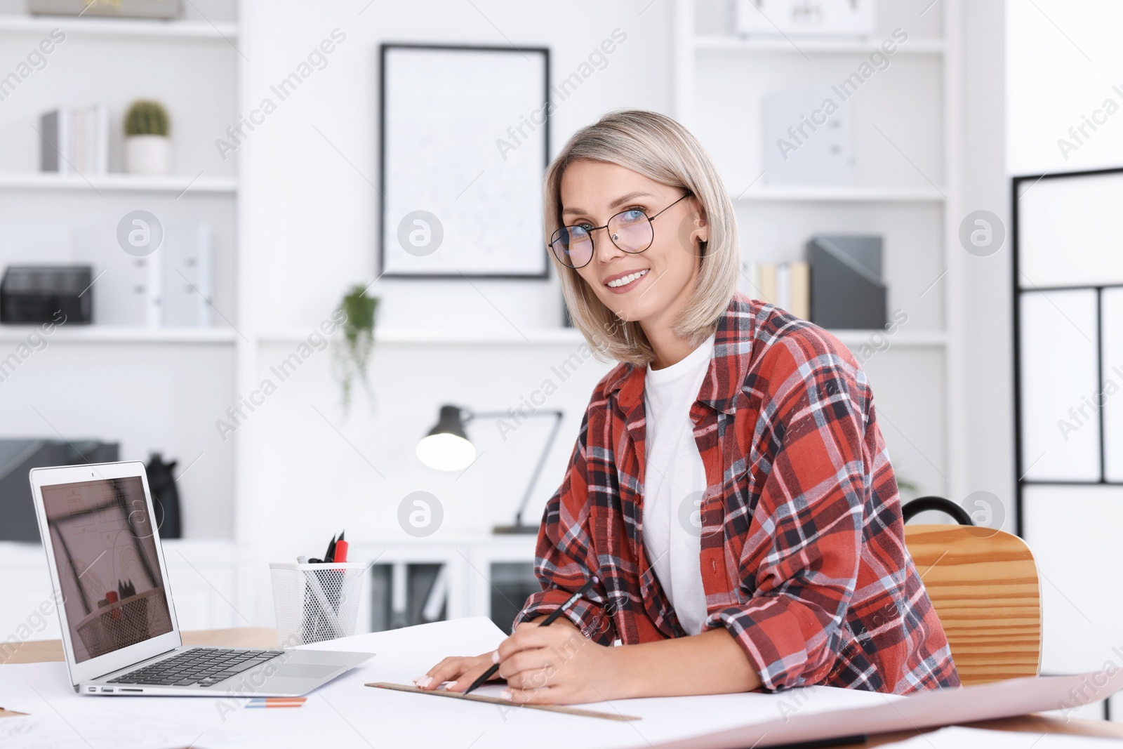 Photo of Architect making engineering drawing at table in office