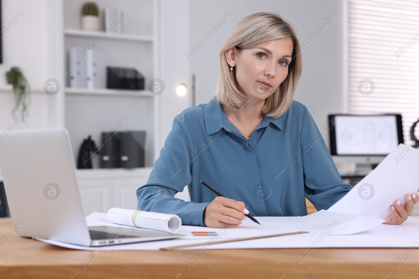 Photo of Architect making engineering drawing at table in office