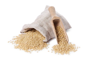 Photo of Raw couscous, overturned burlap sack and wooden scoop isolated on white