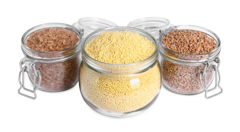 Photo of Different cereal grains in glass jars isolated on white