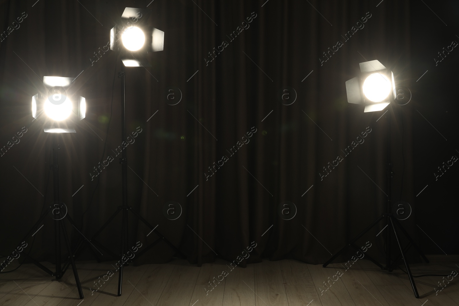 Photo of Spotlights against dark curtain. Professional lighting equipment