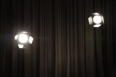 Two spotlights against curtain. Professional lighting equipment