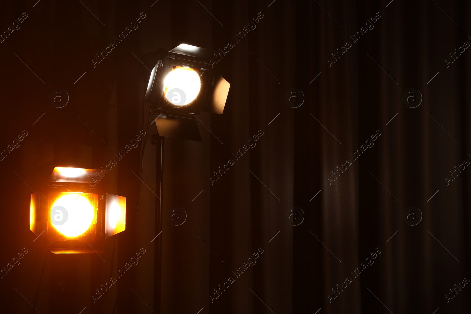 Photo of Professional spotlights against curtain. Space for text