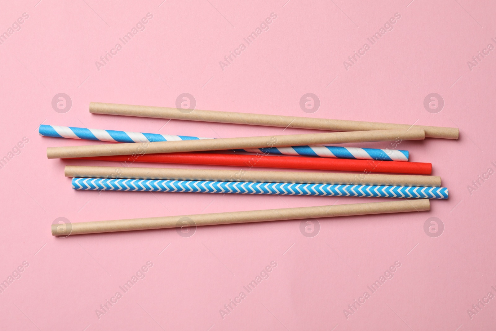 Photo of Bamboo drinking straws on pink background, top view