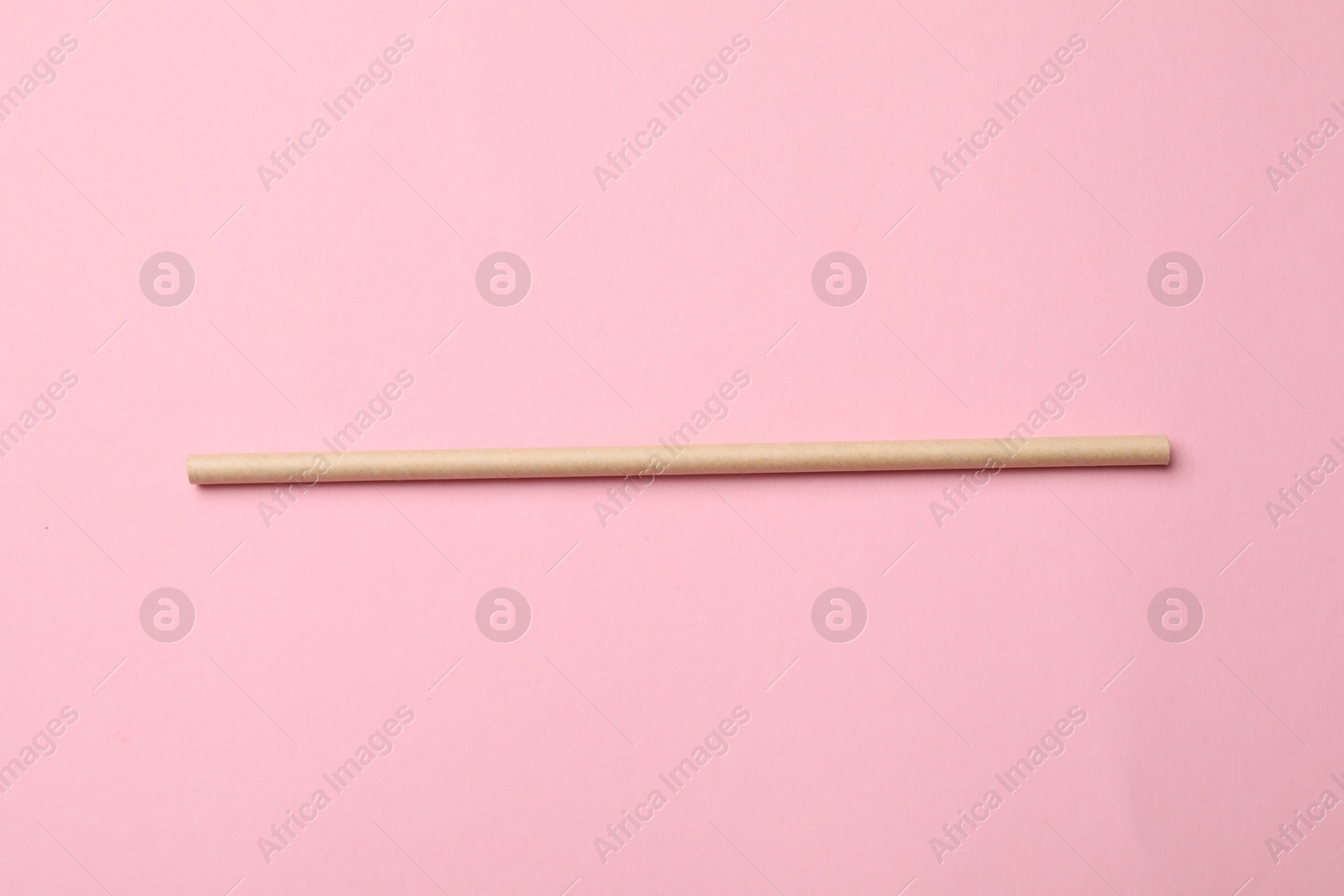 Photo of One bamboo drinking straw on pink background, top view