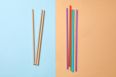 Photo of Plastic and bamboo drinking straws on color background, flat lay