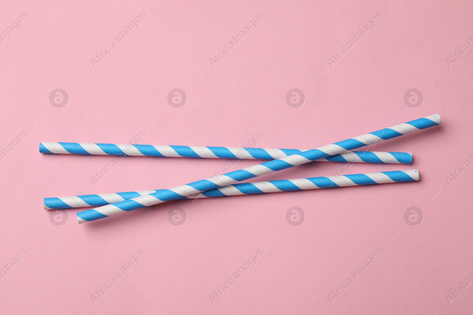 Photo of Bamboo drinking straws on pink background, top view