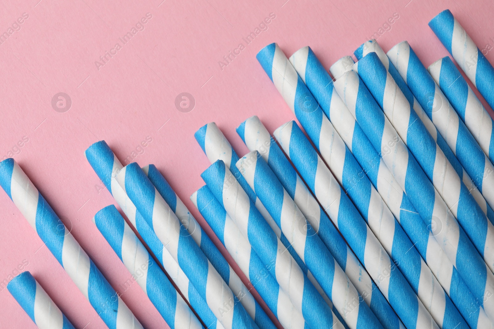 Photo of Bamboo drinking straws on pink background, top view