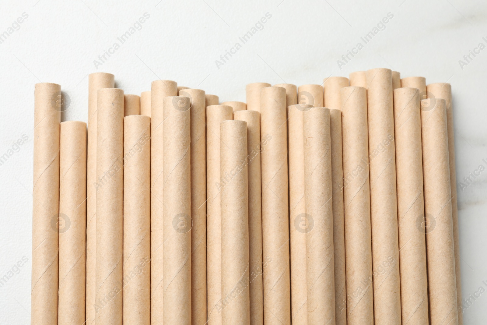 Photo of Many bamboo drinking straws on white table, top view