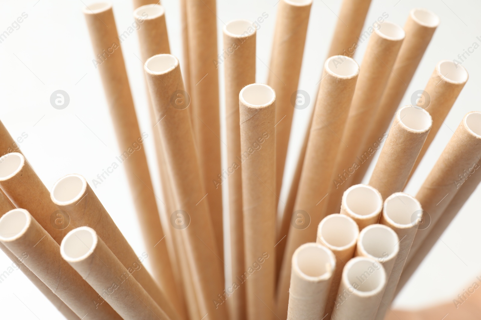 Photo of Many bamboo drinking straws on white background, closeup