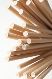 Photo of Many bamboo drinking straws on white background, closeup