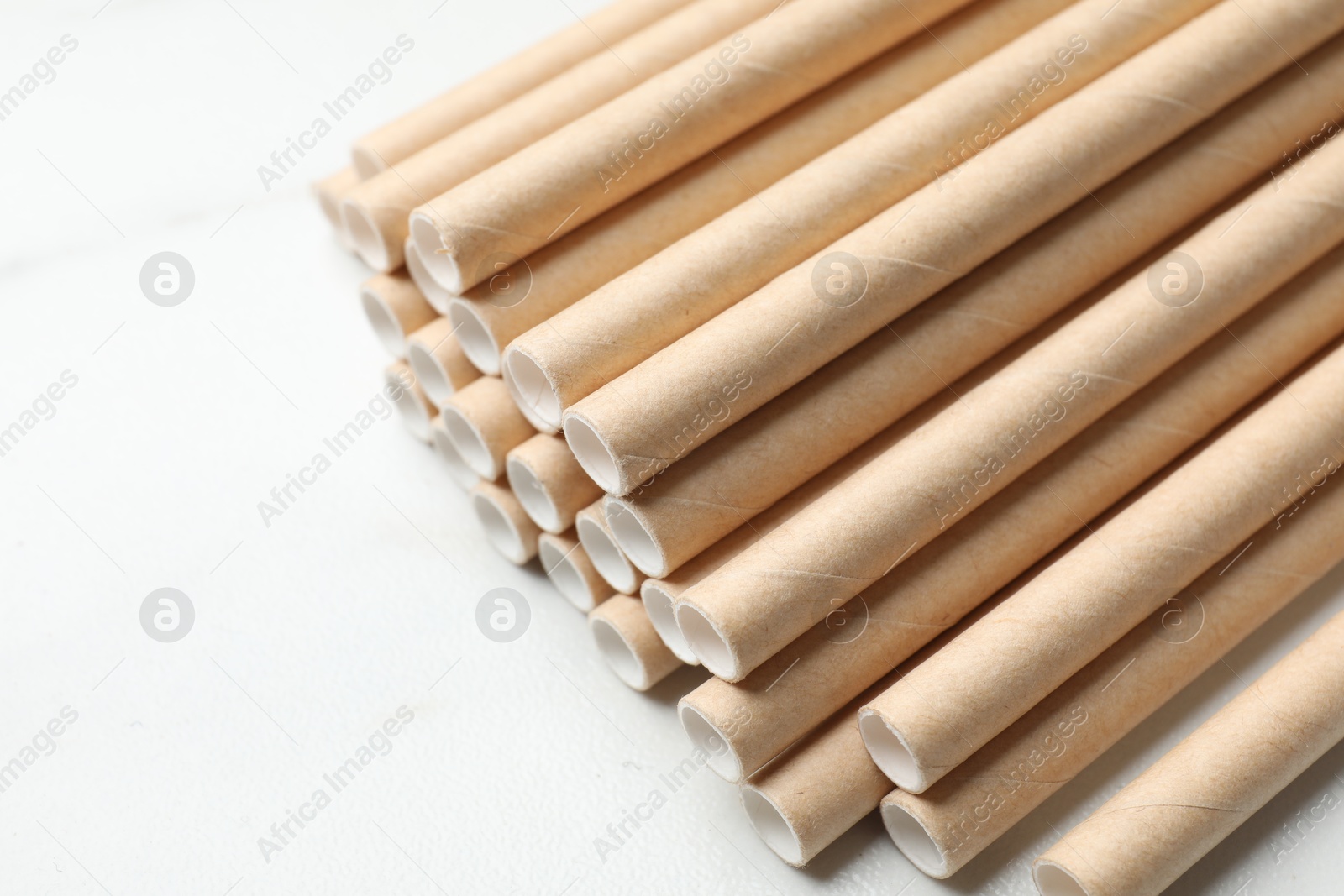 Photo of Many bamboo drinking straws on white background, closeup