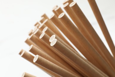 Photo of Many bamboo drinking straws on white background, closeup