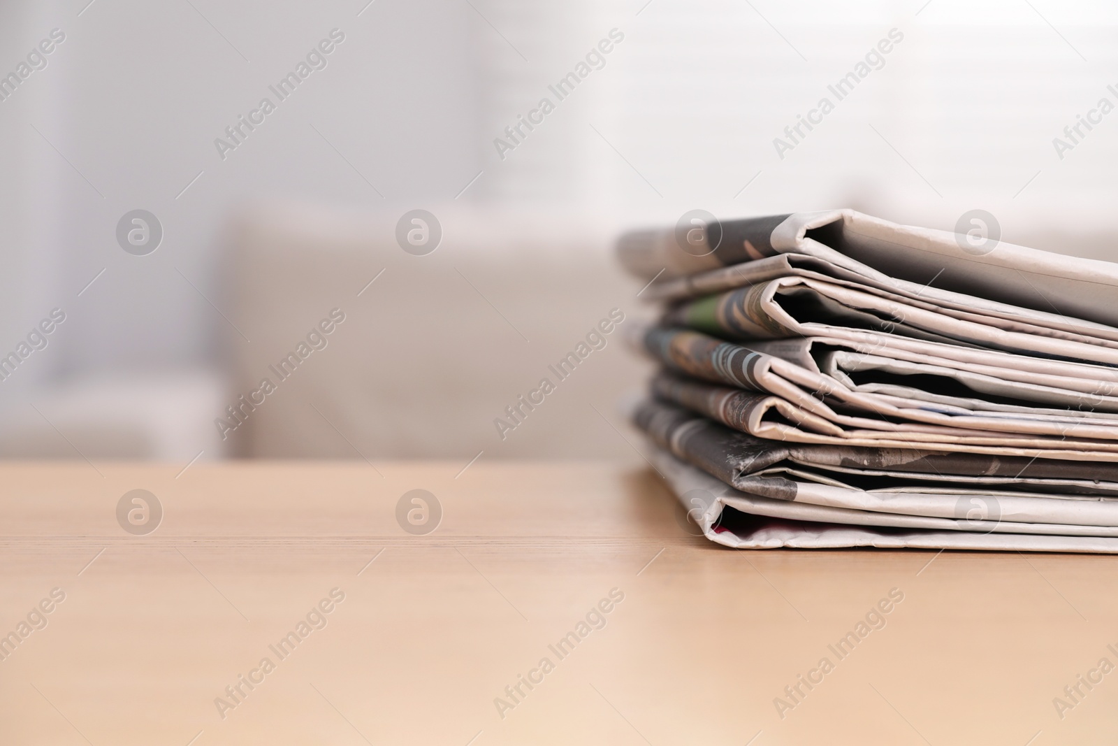 Photo of Stack of newspapers in different languages on table indoors. Space for text