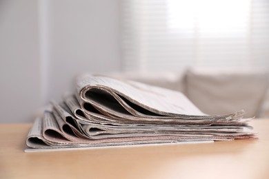 Photo of Stack of newspapers in different languages on table indoors