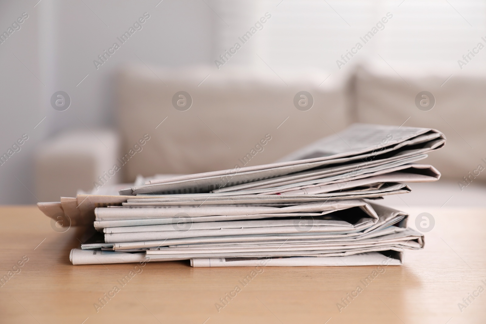 Photo of Stack of newspapers in different languages on table indoors