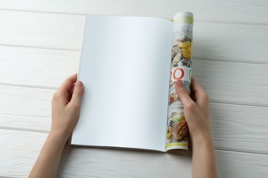 Woman reading magazine at white wooden table, closeup. Mockup for design