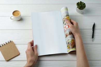 Woman reading magazine at white wooden table, top view. Mockup for design