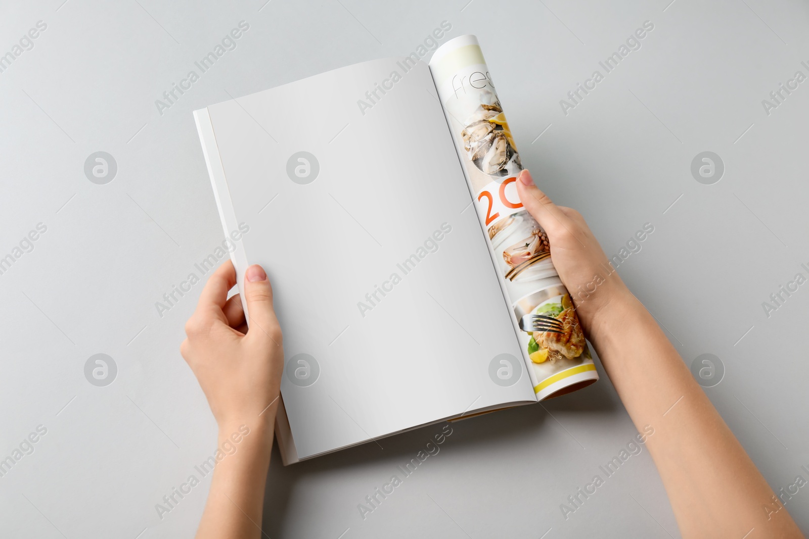 Photo of Woman reading magazine on grey background, top view. Mockup for design