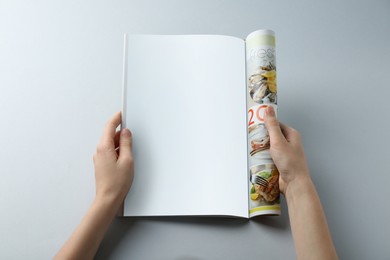 Woman reading magazine on grey background, closeup. Mockup for design