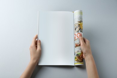 Woman reading magazine on grey background, closeup. Mockup for design