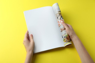 Photo of Woman reading magazine on yellow background, top view. Mockup for design