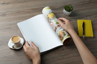 Woman reading magazine at wooden table, closeup. Mockup for design