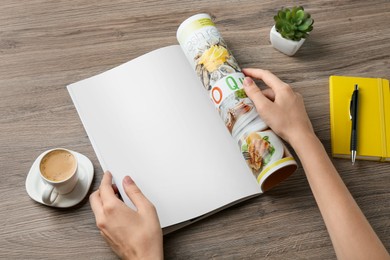 Woman reading magazine at wooden table, closeup. Mockup for design