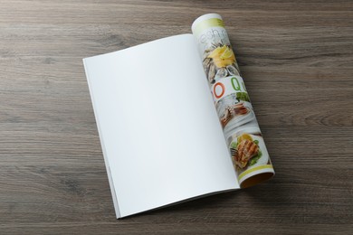 Open magazine with blank page on wooden table, top view. Mockup for design