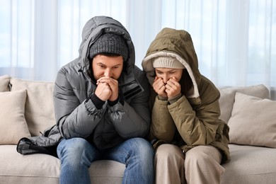 Photo of Cold symptom. Couple suffering from fever on sofa at home