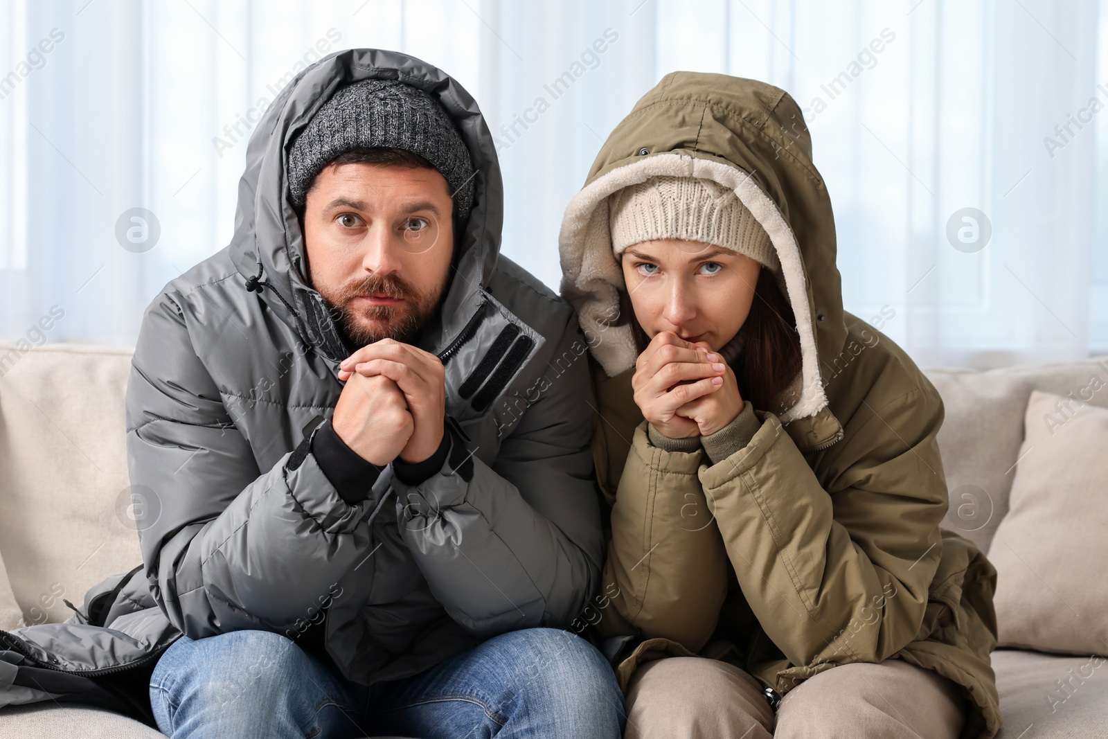 Photo of Cold symptom. Couple suffering from fever on sofa at home