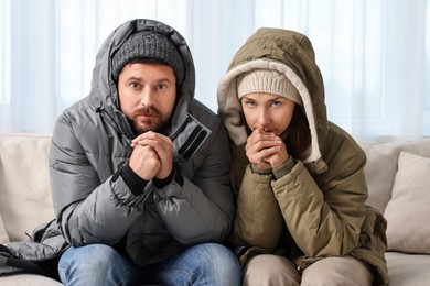 Photo of Cold symptom. Couple suffering from fever on sofa at home