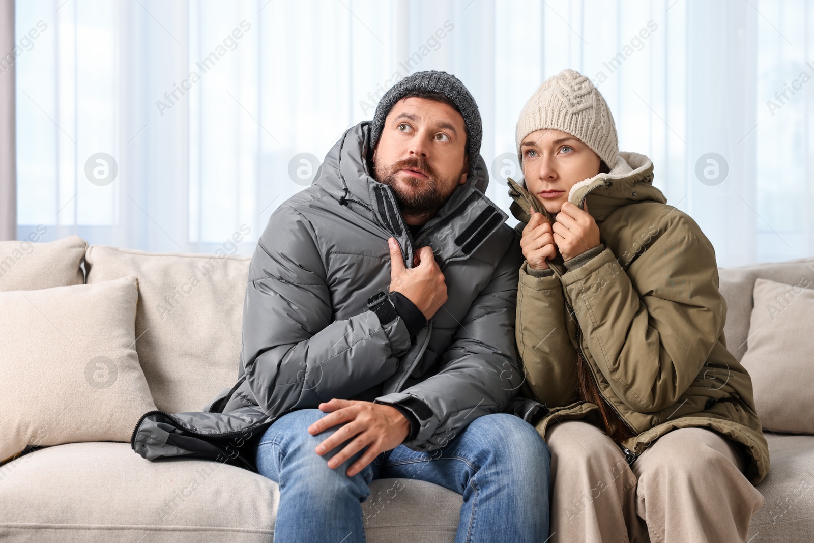 Photo of Cold symptom. Couple suffering from fever on sofa at home