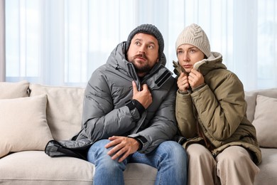 Photo of Cold symptom. Couple suffering from fever on sofa at home