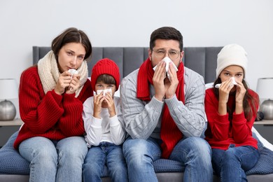 Cold symptom. Family suffering from fever on bed at home