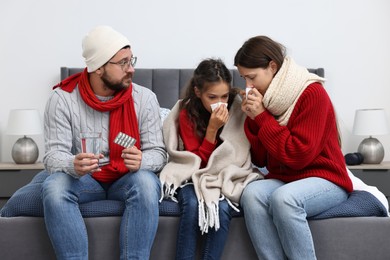 Cold symptom. Family suffering from fever on bed at home