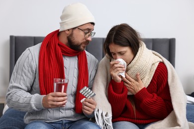 Cold symptom. Couple suffering from fever on bed at home