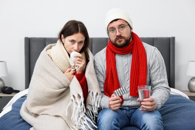 Photo of Cold symptom. Couple suffering from fever on bed at home