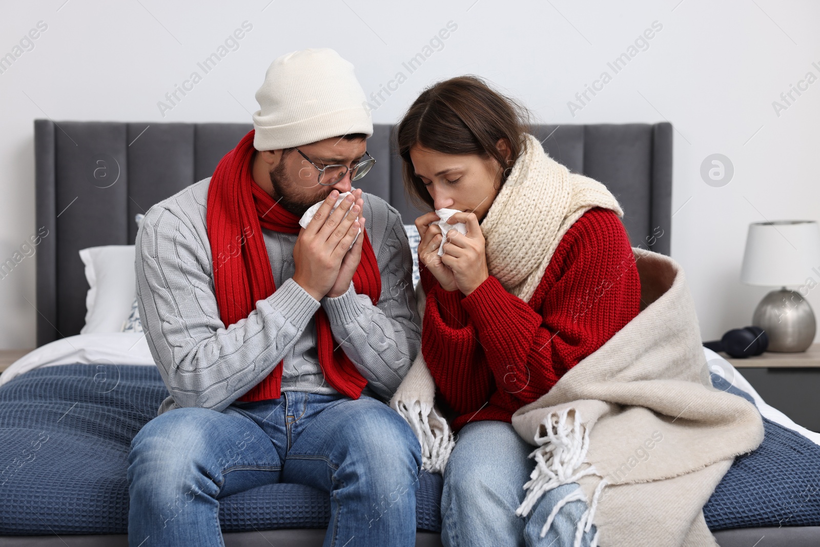 Photo of Cold symptom. Couple suffering from fever on bed at home