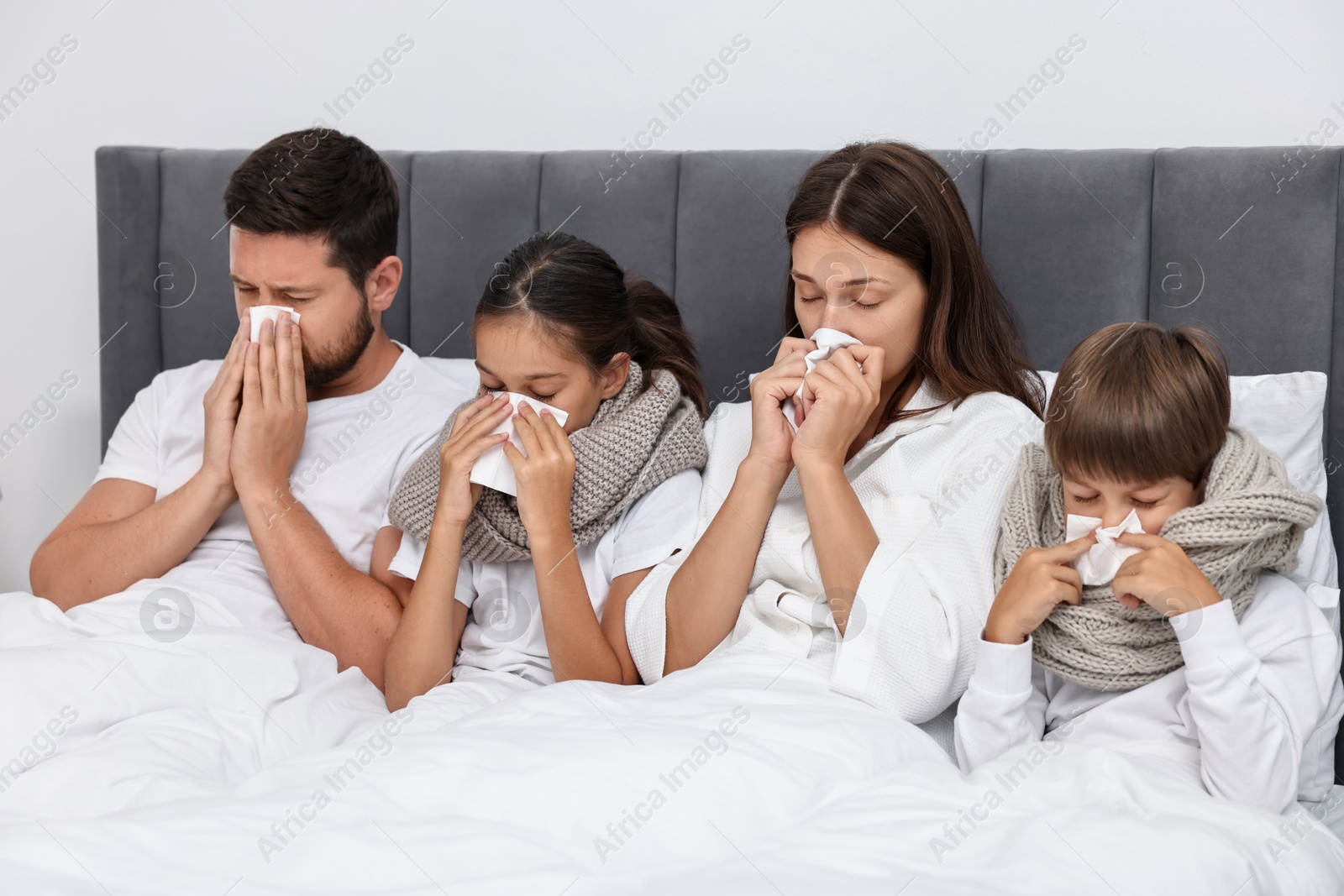 Photo of Cold symptom. Family suffering from fever in bed at home