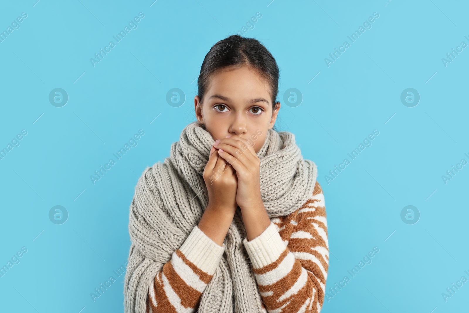 Photo of Cold symptom. Little girl suffering from fever on light blue background