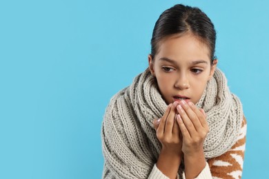 Photo of Cold symptom. Little girl suffering from fever on light blue background