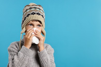 Photo of Cold symptom. Little boy with runny nose on light blue background, space for text