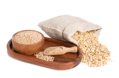 Photo of Dry wheat groats in bowl, scoop and sack with oat flakes isolated on white