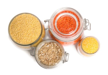 Photo of Different cereals and lentils in jars isolated on white, top view