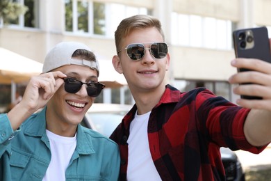 Happy brothers taking selfie on city street