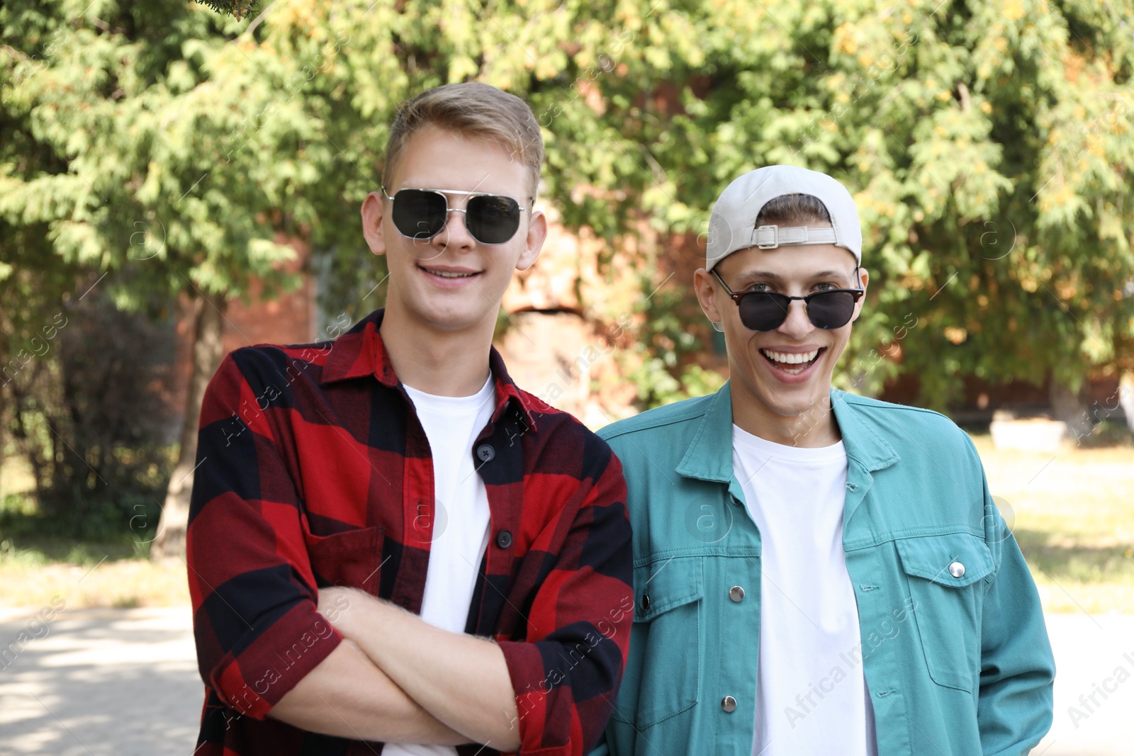 Photo of Family portrait of happy brothers in sunglasses outdoors