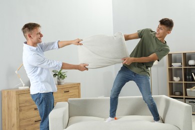 Photo of Happy brothers having pillow fight at home